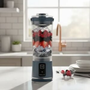 Licuadora portátil Sokany llena de hielo, fresas y frutos rojos sobre la barra de una cocina moderna.